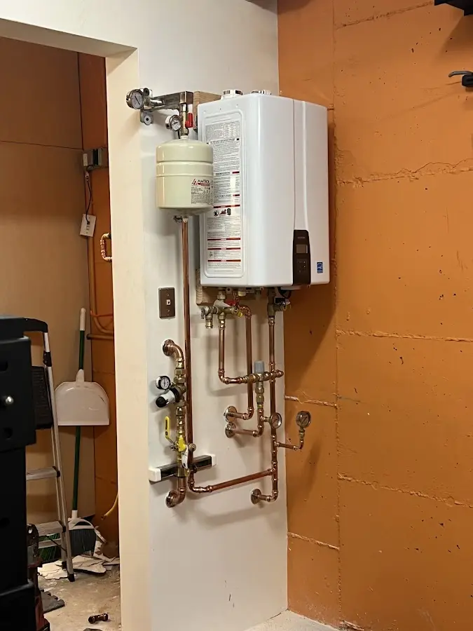 Plumbing technician inspecting water heater connections in Guerneville